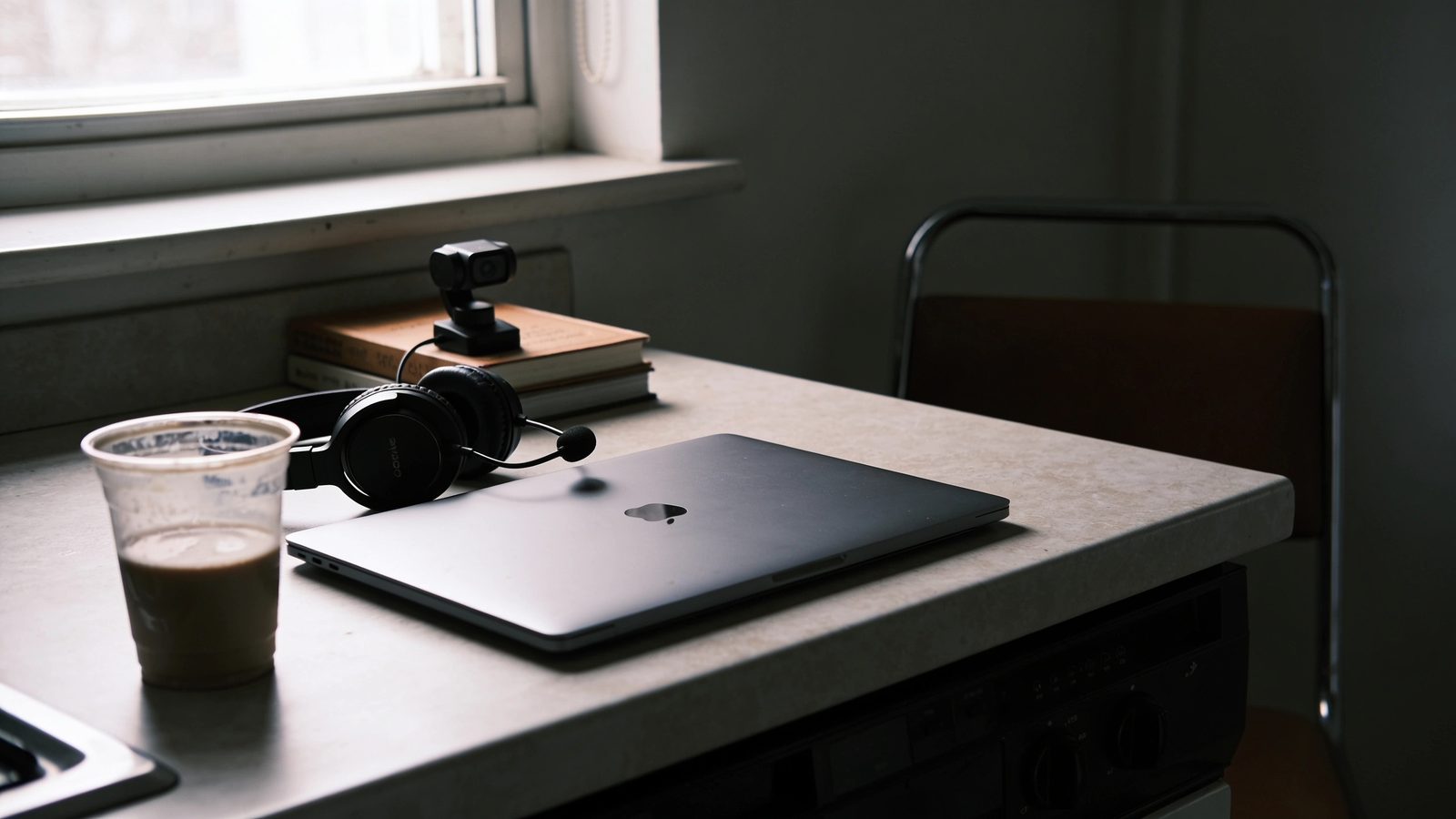 Improvisierter Heimarbeitsplatz mit Notebook, Headset und Webcam